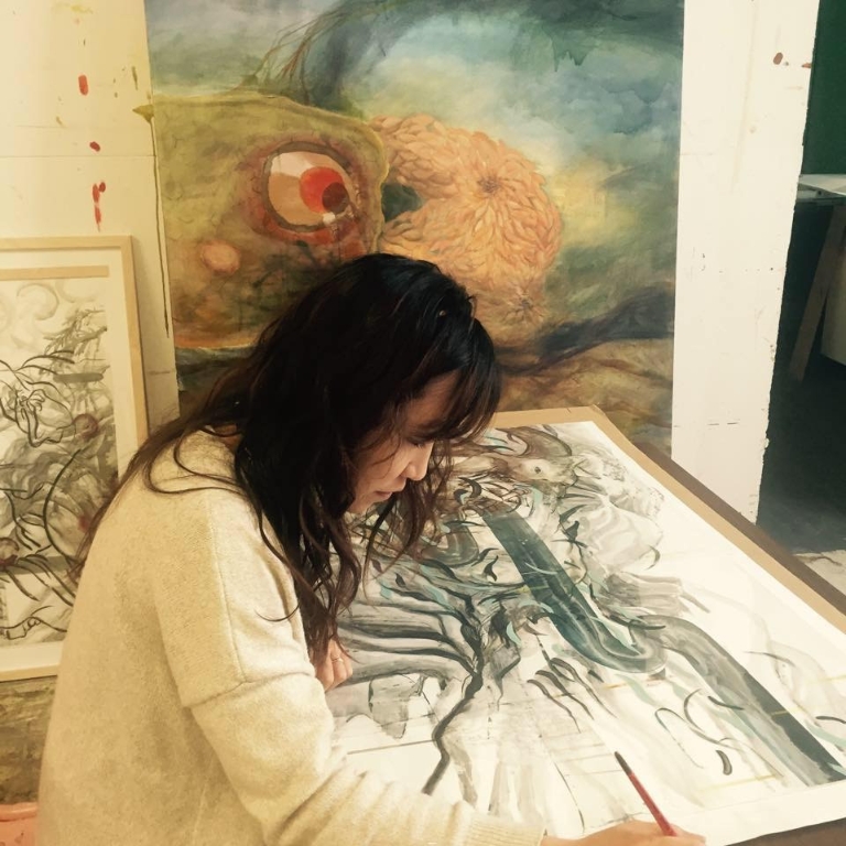 Ann Kim drawing at a studio desk