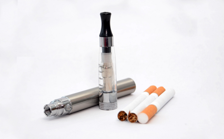 close-up of vape pen and cigarettes