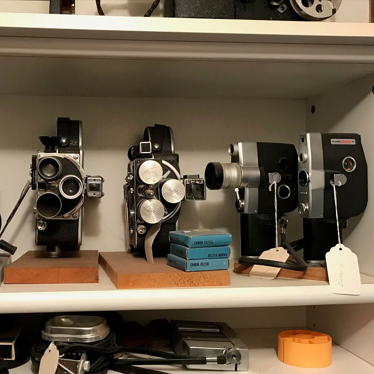 Cameras and projectors on a shelf.