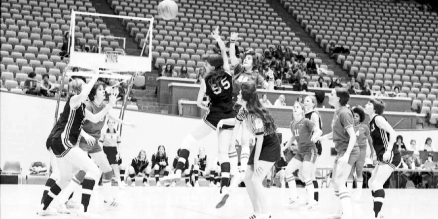 Women's basketball players compete for the ball at the opening tip