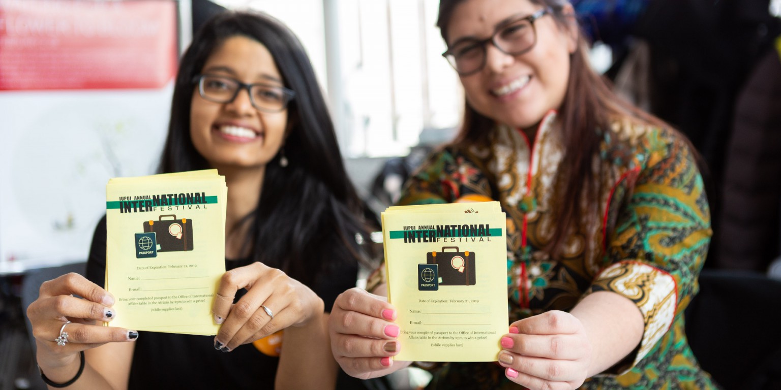 Students pose holding their International Festival passports