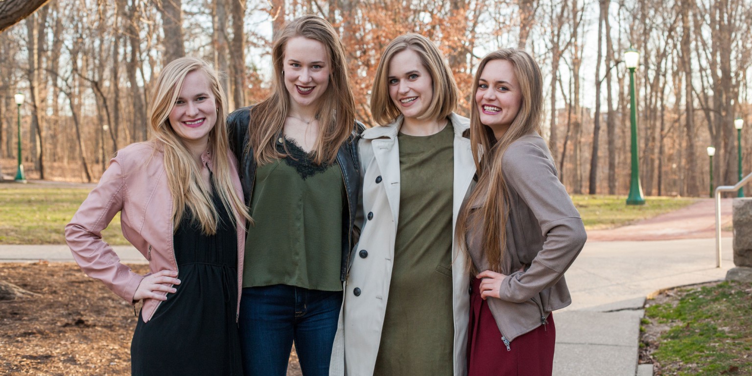 Leah, Tricia, Katherine and Christina stand together on a path smiling. 