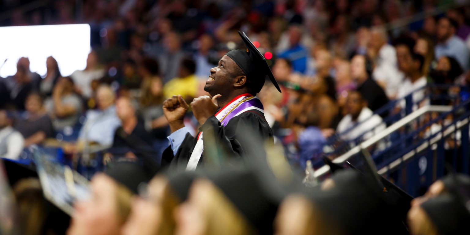 Graduate Desmond Atem reacts as he is recognized by Indiana University South Bend chancellor.