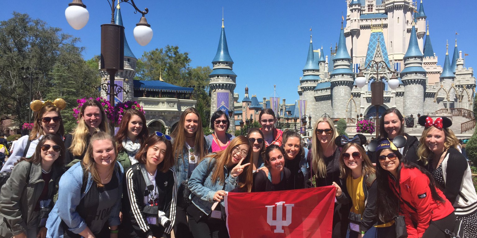 A group of students raise the IU flag at Disney World