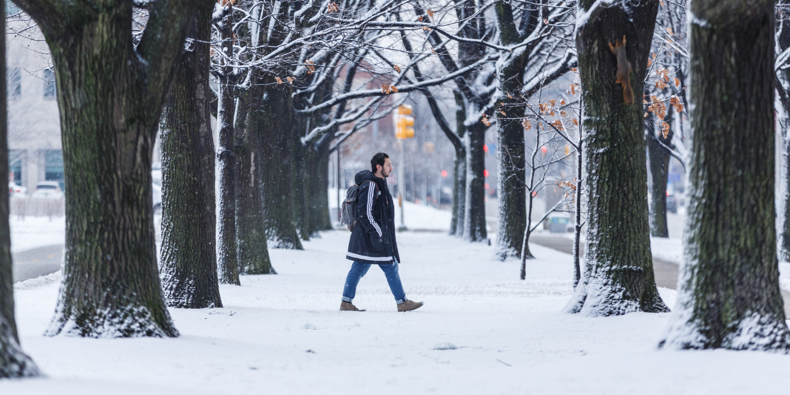 A student walks on campus in the snow