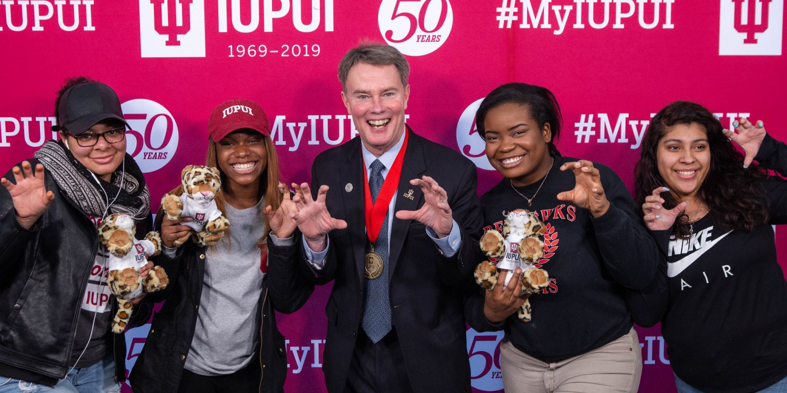 Mayor Joe Hogsett poses for a group photo with IUPUI students holding stuffed jaguars