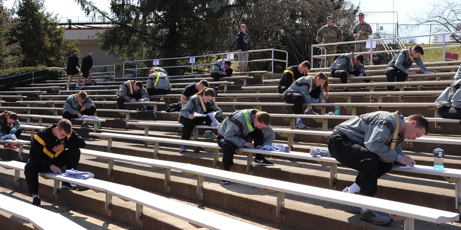 Participants sit on bleachers taking the written test.