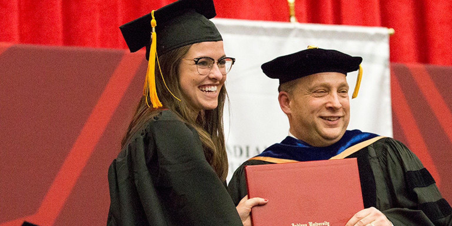 Emily Edwards is presented her diploma by Vice Chancellor and Dean Reinhold Hill.