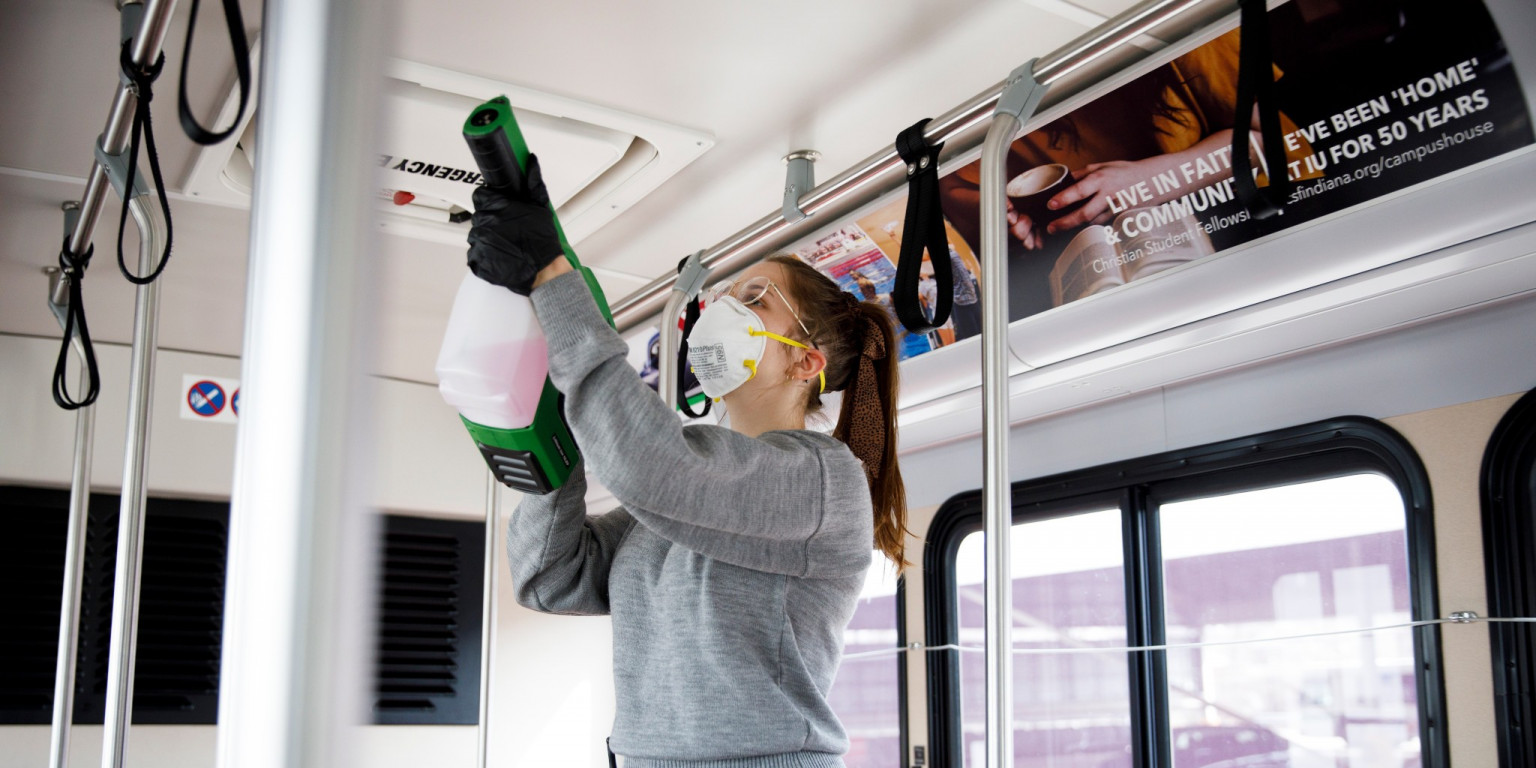 A student supervisor at Indiana University Campus Bus cleans a bus