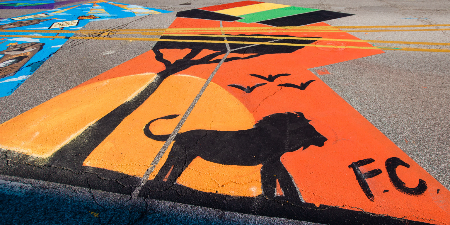 a silhouette of a lion and tree painted in one of the letters of the Black Lives Matter mural