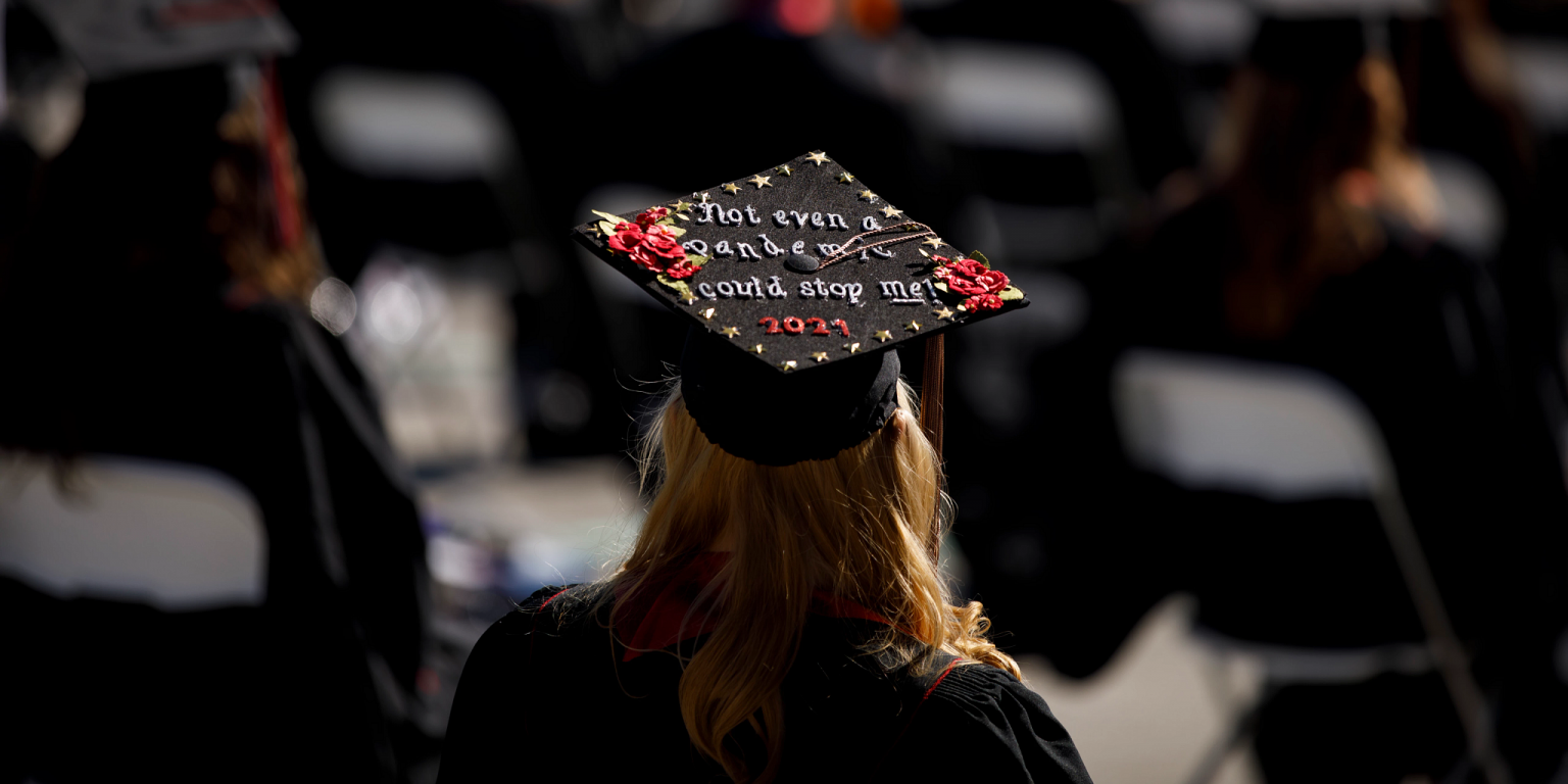 A graduate wears a mortar board decorated with the words 'not even a pandemic could stop me'