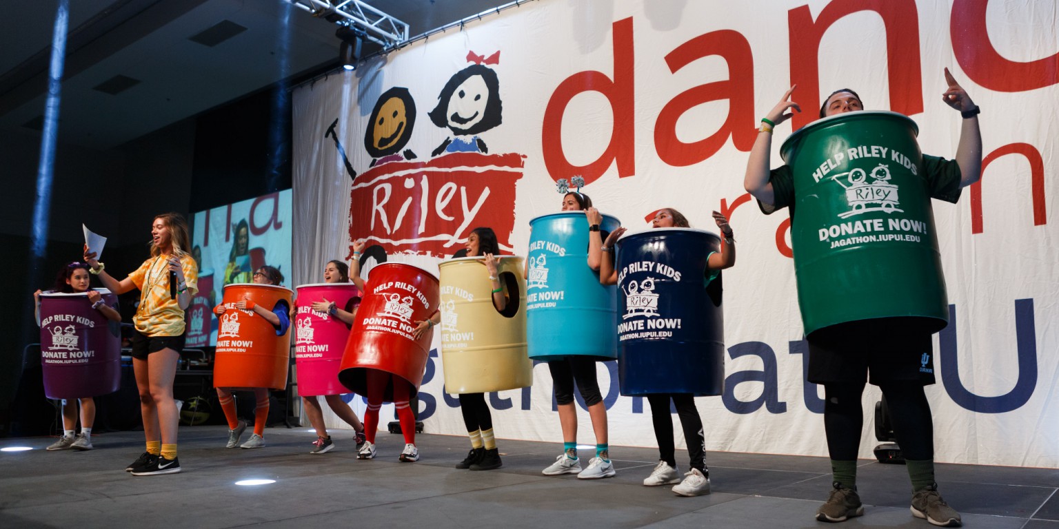 Students wearing Riley Buckets dance on stage at Jagathon