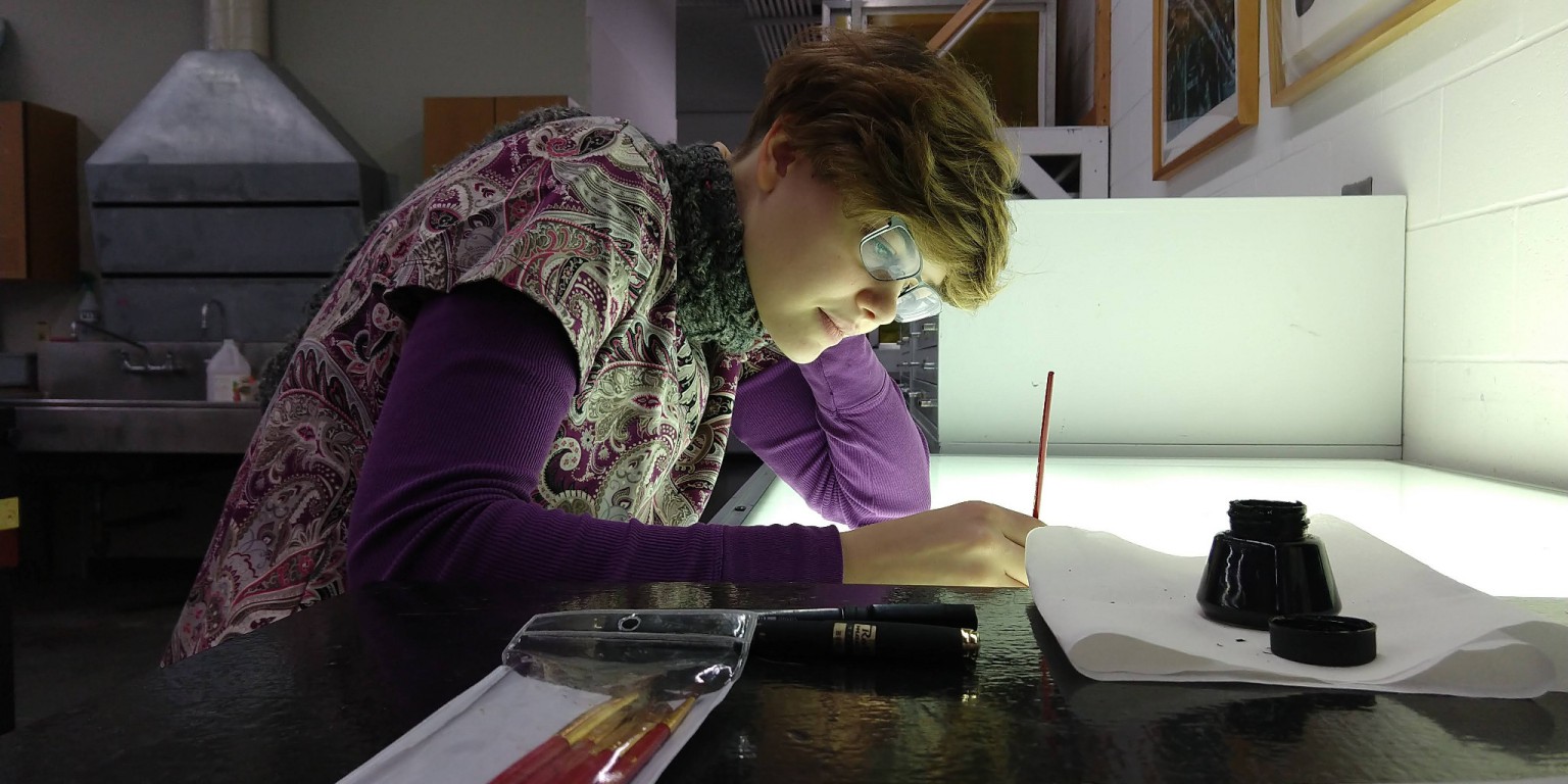 A student draws in the Printmaking Lab.