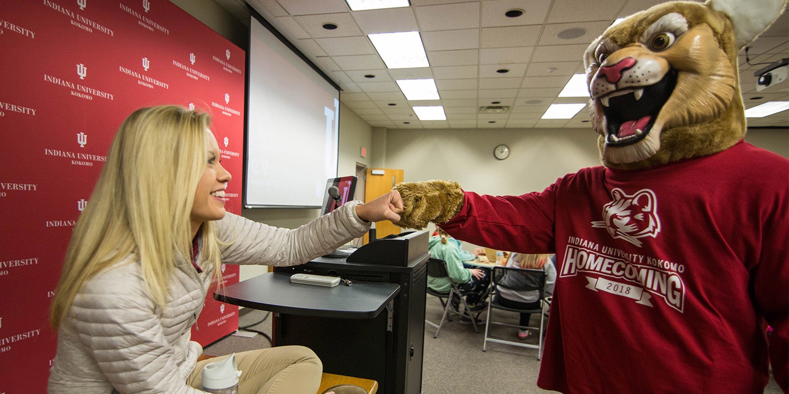 Student Mary Guisewhite does a fist-bump with mascot Kingston