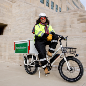 Bike courier pedals documents while peddling benefits of sustainability 