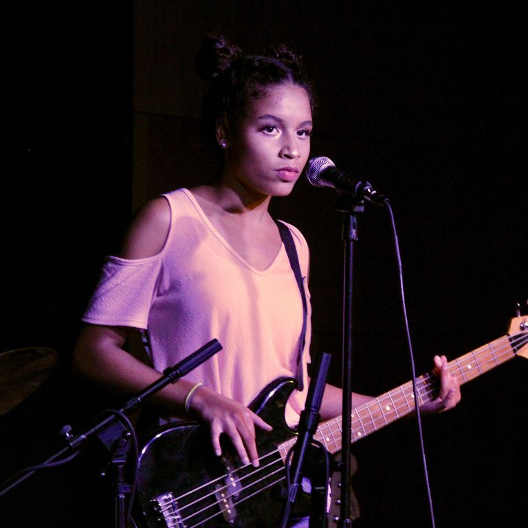 Girl plays bass on-stage.