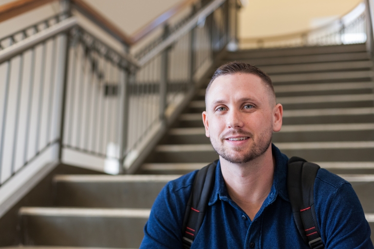 Lucas Sowders sits on a stairs, posing for a photo