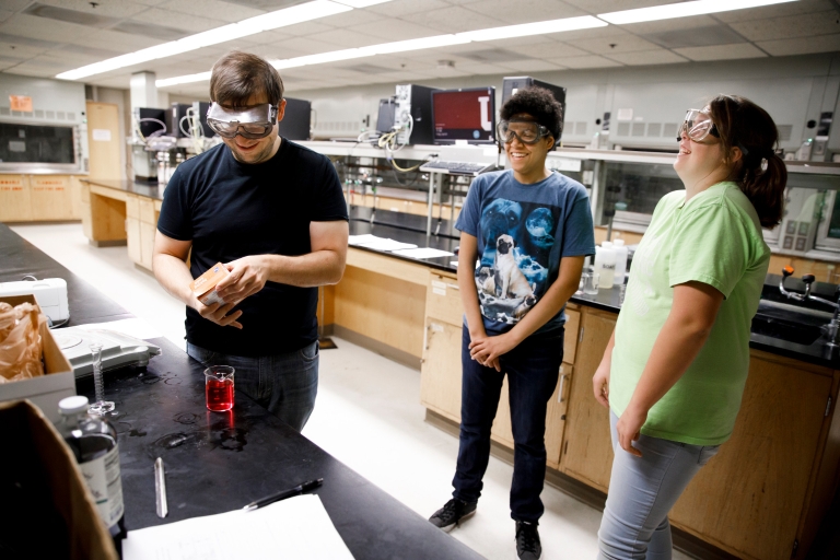 Three students working on an experiment together in a science lab