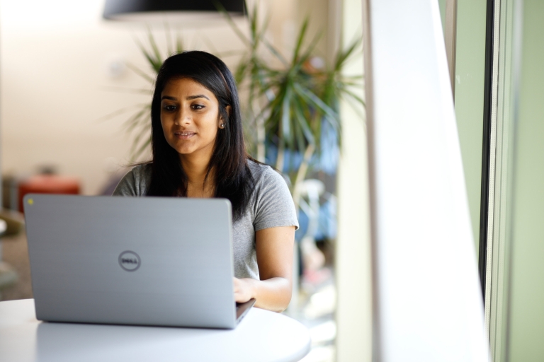 Woman typing on computer laptop