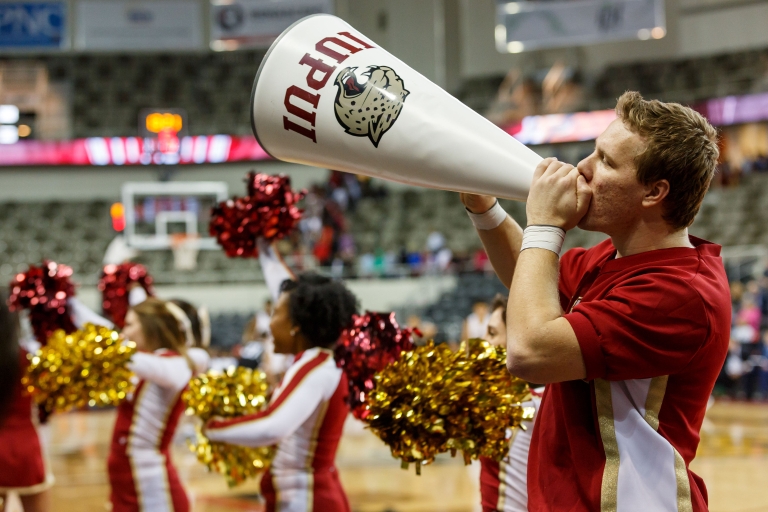 An IUPUI cheerleader riles up the crowd with the help of a megaphone. 