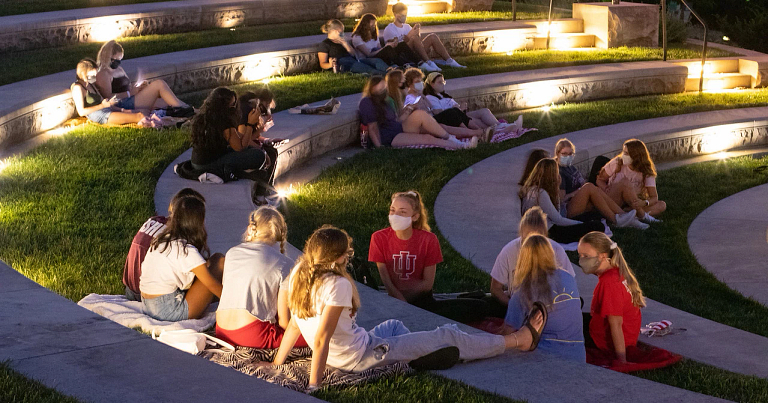Students wearing face masks sit in small groups at the Conrad Prebys Amphitheater in August 2020.