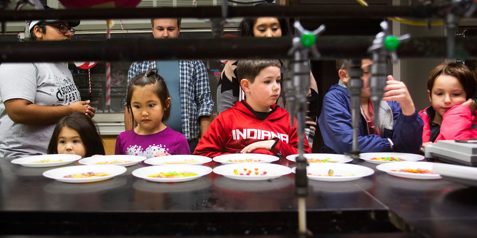 Kids look at Skittles candies during a chemistry demonstration