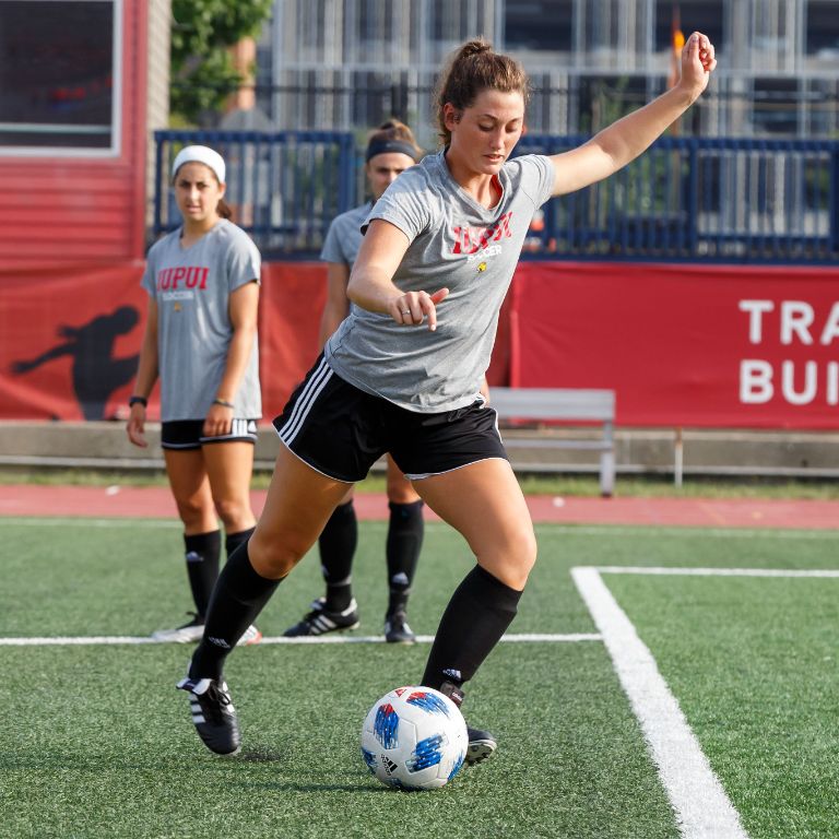 An IUPUI soccer player kicks the ball.