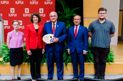 Michael A. McRobbie, Laurie McRobbie and Nasser Paydar pose with two IUPUI students.
