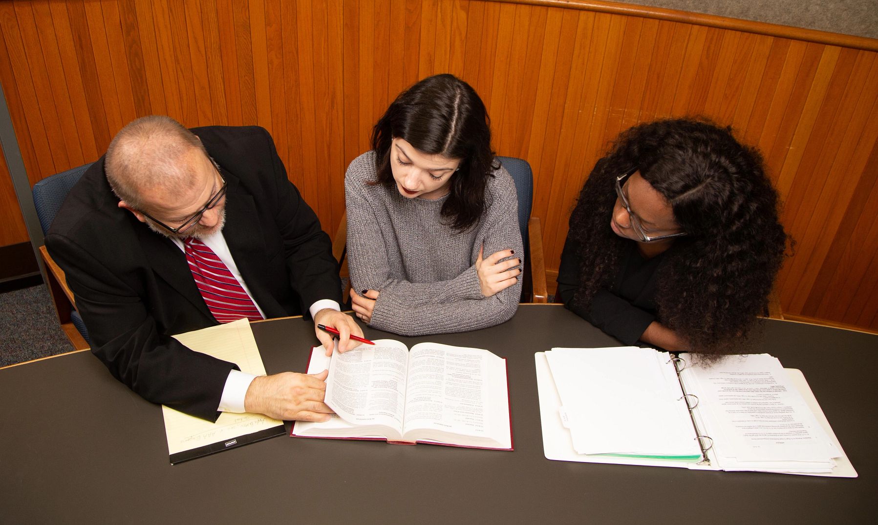 An attorney and two students review documents