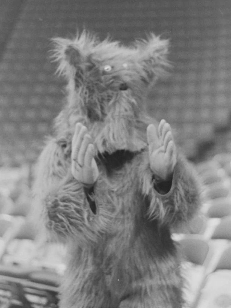 a furry, hairy and rather scary mascot creature claps its hands from 1979