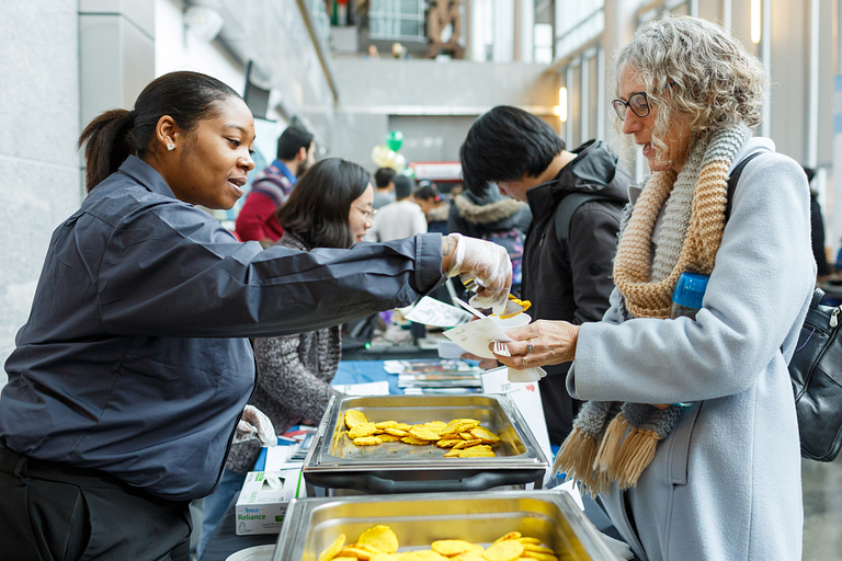 A guests receives a food sample at the International Festival