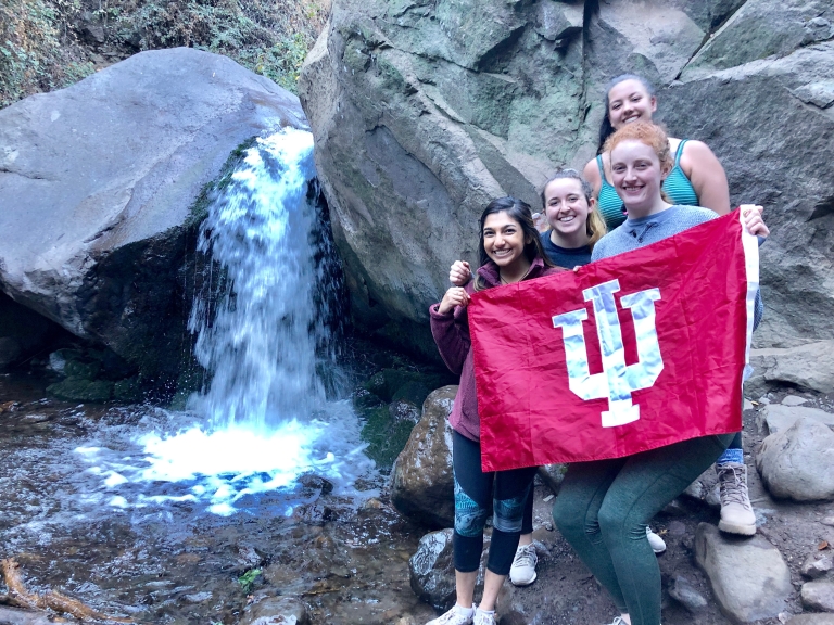 Students raise the IU flag in front of a waterfall in Chile