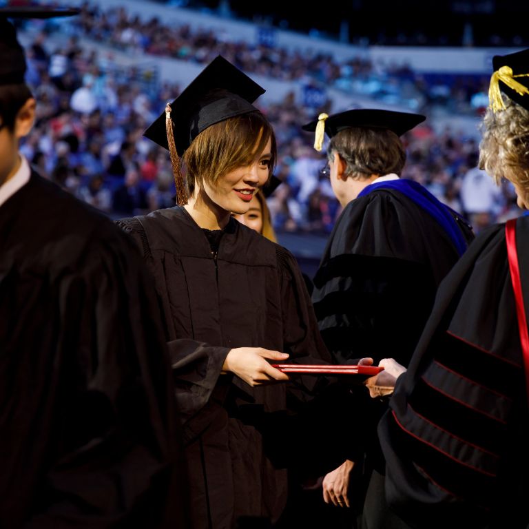 A graduate receives her diploma.