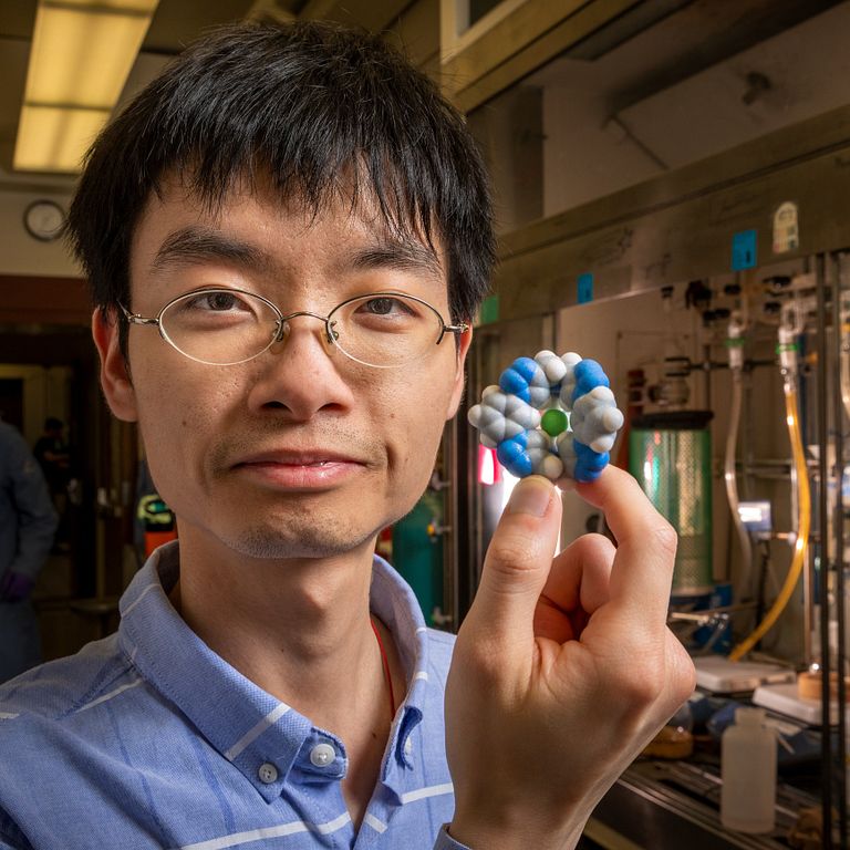 Yun Liu holds a 3D-printed model of the chloride capture molecule