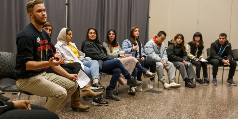 Students sit in a room in the Campus Center to debrief and process the event.