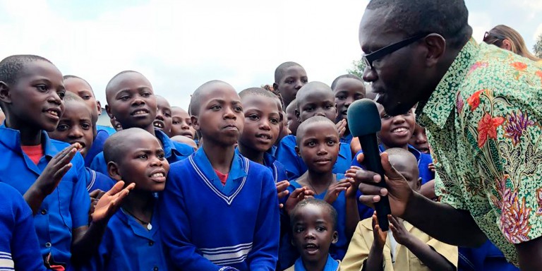 Simon Pierre Munyaneza sings with children during the end-of-camp celebration