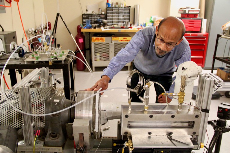 Nalim adjusts an engine rig in his lab.