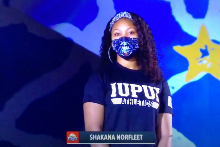 Shakana Norfleet wearing a face mask and preparing to sing the national anthem live on CBS