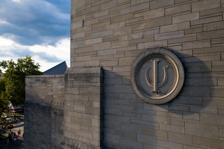 An IU trident on the limestone exterior of IU Auditorium