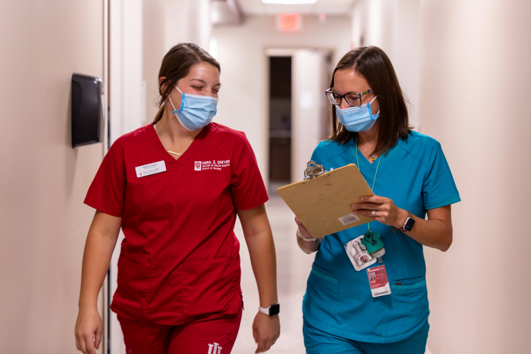 Two healthcare specialists walking down a hallway