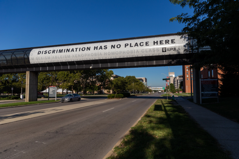 An anti-discrimination banner hangs from the Michigan and Blake streets walkway