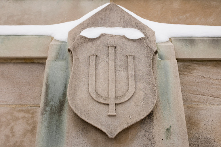 The IU trident etched in a limestone crest topped with snow
