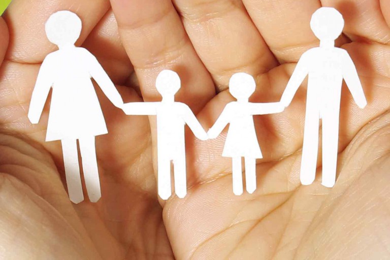 Hands holding a paper cut-out family