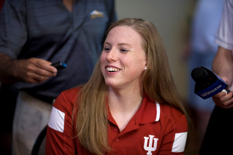 Lilly King sits in a red IU shirt and answers questions from reporters