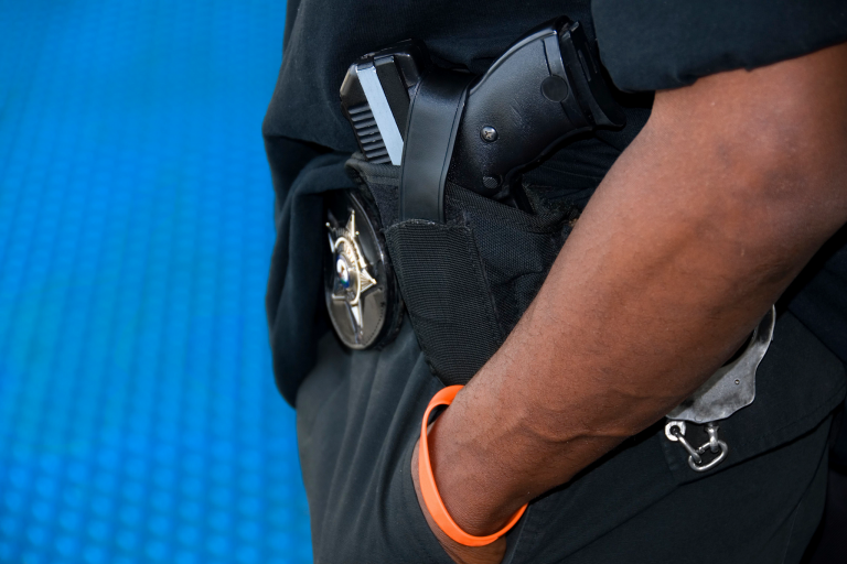 Black police officer's hands in pockets