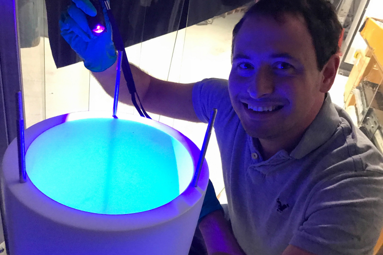 IU Ph.D. student Jacob Zettlemoyer with a substance used to detect neutrinos using argon light.