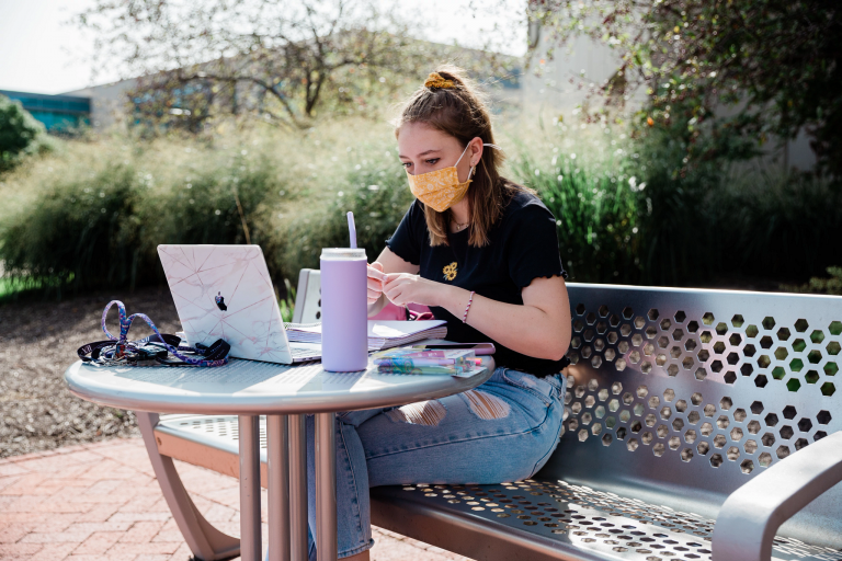 Student studying outside University Library at IUPUI.