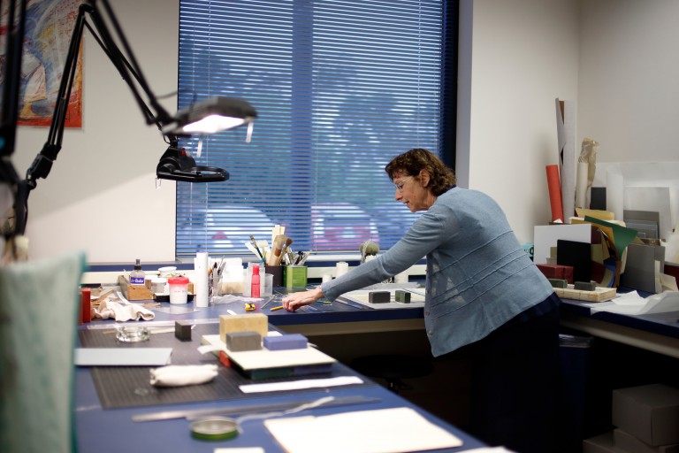 Elise Calvi working in the preservation lab conserving the historical collections.