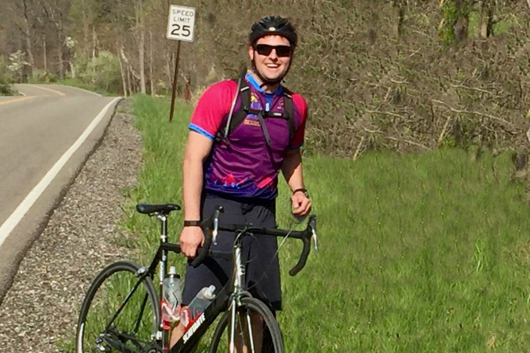 SPEA health economist Alex Hollingsworth stands next to his bicycle.