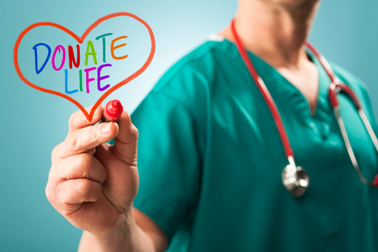 a doctor holding a heart with the words donate life on it